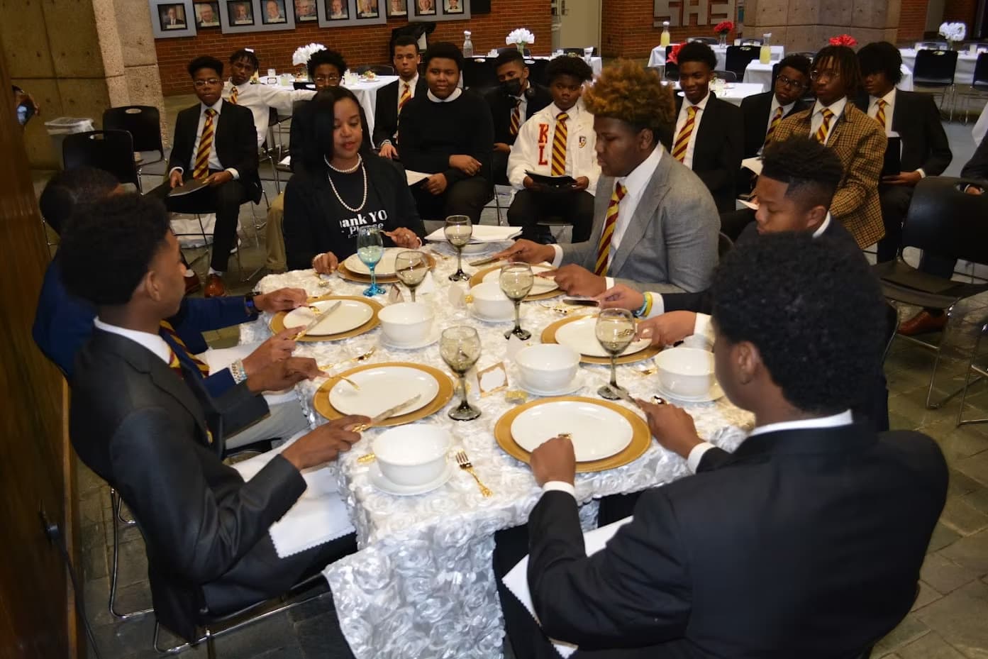 Guests seated at a formal dining table during an etiquette session.